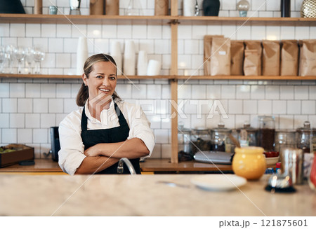 Business owner, barista standing with arms crossed, looking confident and proud while working at a restaurant. Cafe worker, employee and entrepreneur smiling, giving service and leading a coffee shop 121875601