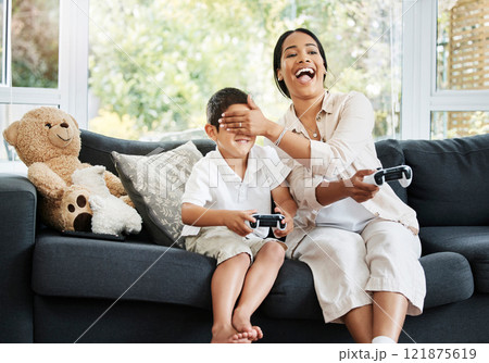 Mother and son playing video games, having fun and enjoying quality time together. Cheerful, bonding and carefree child and parent using a gaming console or interactive modern technology 121875619