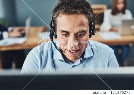 Closeup of a young male call center agent consulting and giving support while working in a busy office. Face of a man and helpdesk worker or phone operator having a conversation Closeup of a young male call center agent consulting and giving support while working in a busy office. Face of a man and helpdesk worker or phone operator having a conversation 121876275