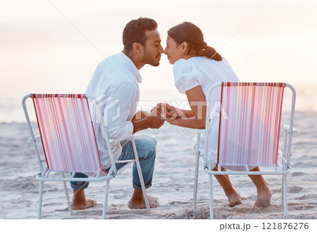 Couple, beach chair and holding hands on holiday, love and outdoor at sunset, back and bonding in summer. People, man and woman with nose, touch and relax with play on vacation by ocean in Indonesia 121876276