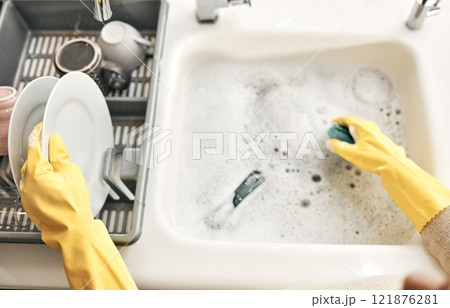 Housewife, maid or cleaner hands washing dishes in the kitchen sink for home hygiene, wearing rubber gloves. Contact us for cleaning solutions or professional domestic household chores service. 121876281
