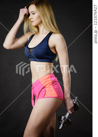 Woman working out at home with dumbbell Woman working out at home with dumbbell 121876427