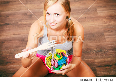 Diet. Girl with colorful measuring tapes in bowl Diet. Girl with colorful measuring tapes in bowl 121876448