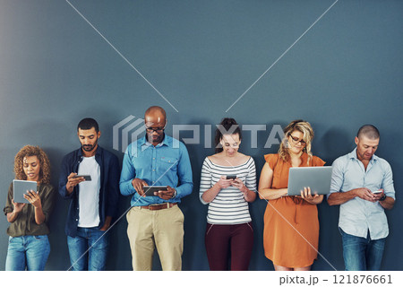 A group of people distracted due to the overuse of technology against gray studio background. Many employees are addicted and obsessed with social media with a dependence on gadgets or devices A group of people distracted due to the overuse of technology against gray studio background. Many employees are addicted and obsessed with social media with a dependence on gadgets or devices 121876661
