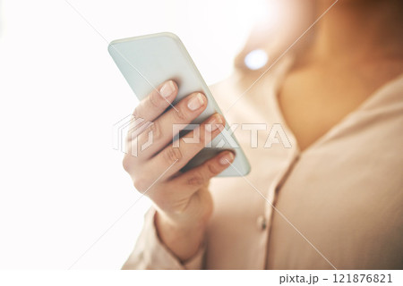 Phone in hand, communication and networking with a woman reading, typing or sending a text message. Closeup of a female browsing social media, surfing the internet and checking news online with flare 121876821