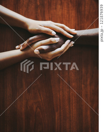 Support, love and a couple holding hands at a table from above with copyspace. Interracial friends praying, consoling and showing care at therapy or after bad news. Unity and affection after grief. 121876939