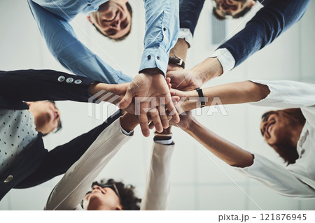 Team of business people hands stacked showing teamwork, collaboration and standing united for project development and innovation. Group of corporate colleagues joining in support and unity from below 121876945