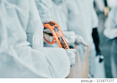 Covid healthcare workers responding to a biohazard in a public area using barrier tape. First responders in protection hazmat suits cordoning a space due to a new pandemic or outbreak Covid healthcare workers responding to a biohazard in a public area using barrier tape. First responders in protection hazmat suits cordoning a space due to a new pandemic or outbreak 121877177