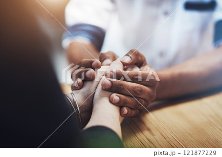 Interracial couple holding hands in support, comfort and trust while bonding and feeling united in home living room. Closeup of man touching, comforting or caring for woman who has anxiety in therapy 121877229