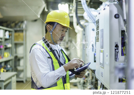 タブレットを持って点検する男性作業員　撮影協力：学校法人電波学園　東京電子専門学校 121877251