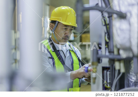タブレットを持って点検する男性作業員　撮影協力：学校法人電波学園　東京電子専門学校 121877252