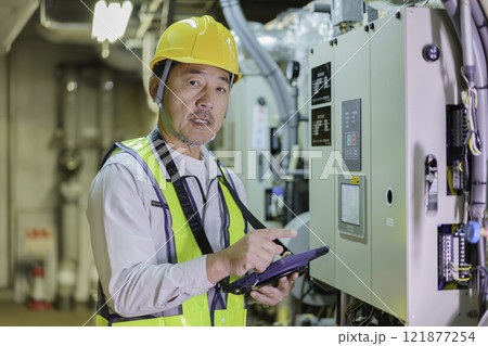 タブレットを持って点検する男性作業員　撮影協力：学校法人電波学園　東京電子専門学校 121877254