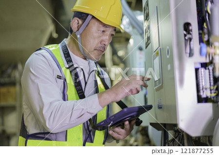 タブレットを持って点検する男性作業員　撮影協力：学校法人電波学園　東京電子専門学校 121877255