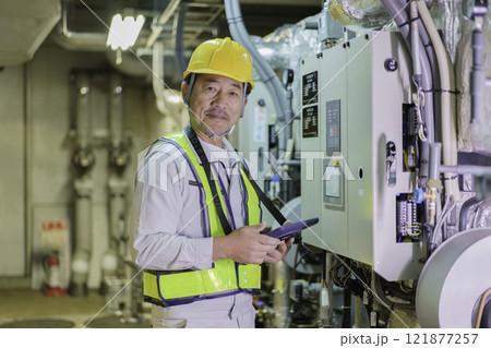 タブレットを持って点検する男性作業員　撮影協力：学校法人電波学園　東京電子専門学校 121877257
