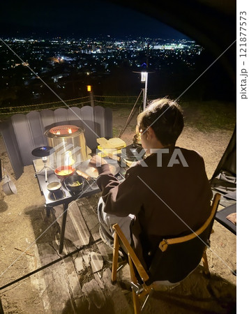 キャンプでの焚き火をする大学生 121877573