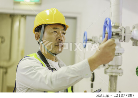 バルブを閉める男性作業員　撮影協力：学校法人電波学園　東京電子専門学校 121877897