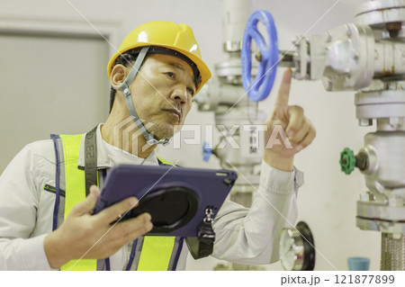 バルブを点検する男性作業員　撮影協力：学校法人電波学園　東京電子専門学校 121877899