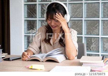 Young woman reading a book with music. 121878873