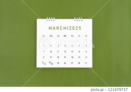 March 2025 Monthly desk calendar on green leather background. 121879737