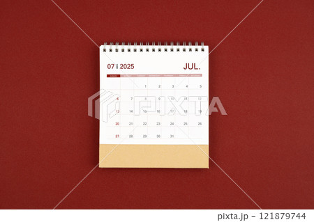 July 2025 desk calendar on red leather. July 2025 desk calendar on red leather. 121879744