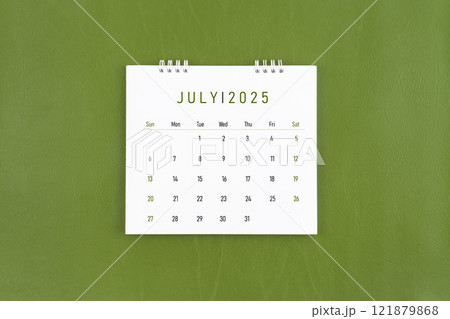 July 2025 Monthly desk calendar on green leather background. July 2025 Monthly desk calendar on green leather background. 121879868