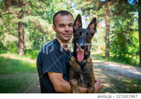 young Caucasian hipster spends time with his dog in the park on a sunny summer day. The concept of a pet as a family member 121881967