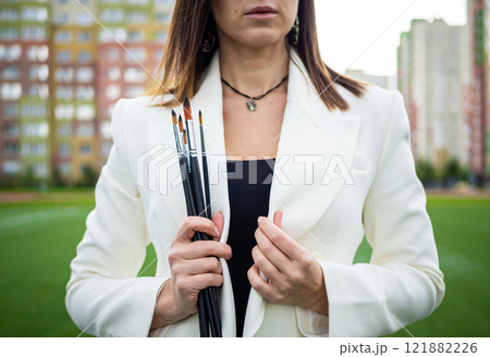 Brunette, female artist paints in nature. Brunette, female artist paints in nature. 121882226