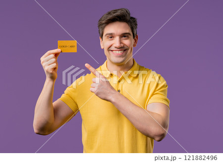Successful man in shirt showing unlimited gold credit card on violet studio background. Student, money concept. 121882496