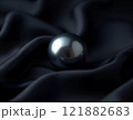Single black pearl on elegant dark fabric 121882683