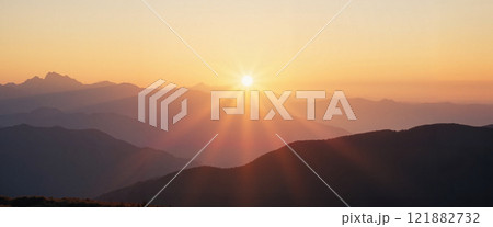 Stunning sunrise over mountain range showcasing vibrant colors and serene landscape in peaceful morning light 121882732