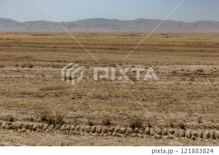 Vast arid landscape in Kunduz Province Afghanistan with sparse vegetation and distant hills Vast arid landscape in Kunduz Province Afghanistan with sparse vegetation and distant hills 121883824
