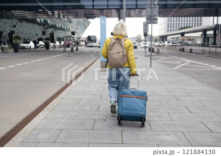 Senior female tourist in airport hold suitcase valise passport ticket schedule to check flight departure gate. Travel and tourism concept, people with backpack on shoulders. 121884130