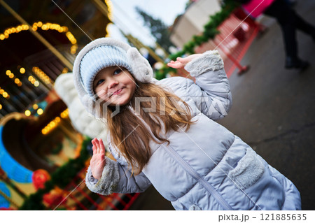 Young girl enjoying a winter fair in a cozy jacket and hat Young girl enjoying a winter fair in a cozy jacket and hat 121885635