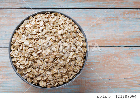 Bowl of Oat Flakes on Rustic Wooden Boards, Wholesome Breakfast Ingredients, Top View, Copy Space 121885964