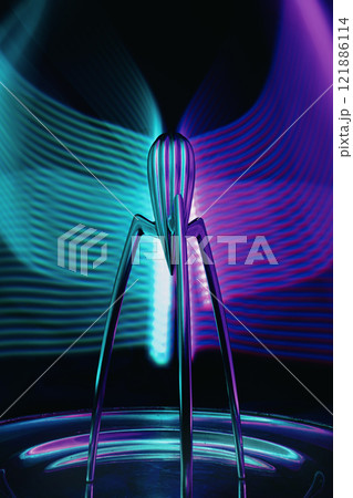A vibrant purple and blue light is brilliantly shining on a statue 121886114