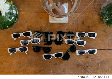 A collection of stylish sunglasses is spread out on a wooden table A collection of stylish sunglasses is spread out on a wooden table 121886143