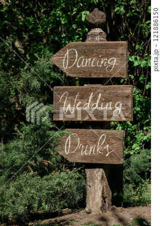 A wooden sign pointing to dancing, wedding, and drinks A wooden sign pointing to dancing, wedding, and drinks 121886150