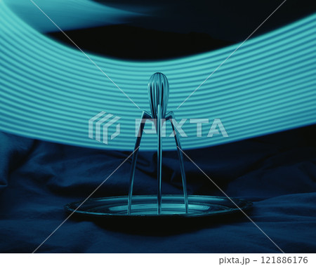 A blue light on Juicy Salif by Philippe Starck citrus juicer is resting on a plate with a blue light behind it A blue light on Juicy Salif by Philippe Starck citrus juicer is resting on a plate with a blue light behind it 121886176