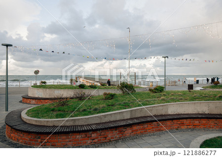 A park with a brick wall and grassy area by the ocean A park with a brick wall and grassy area by the ocean 121886277