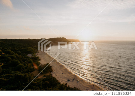 An aerial view showcasing a beautiful beach during a stunning sunset An aerial view showcasing a beautiful beach during a stunning sunset 121886324