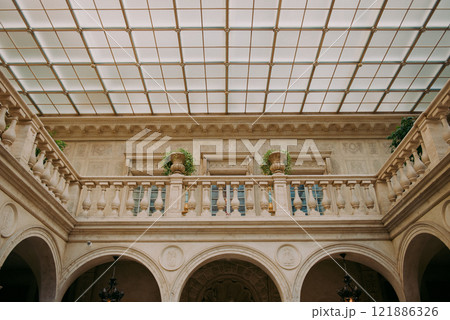 A beautiful balcony situated in a building featuring a glass ceiling 121886326