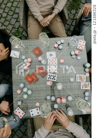 A diverse group is around a large table, fully engaged in poker A diverse group is around a large table, fully engaged in poker 121886328