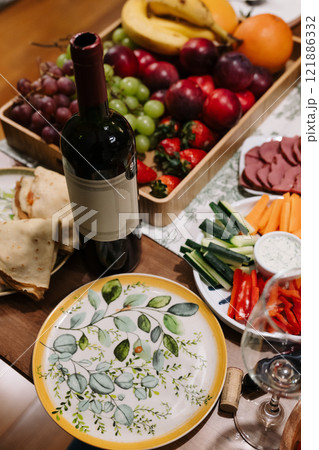 A table topped with delicious food plates and fine wine A table topped with delicious food plates and fine wine 121886332