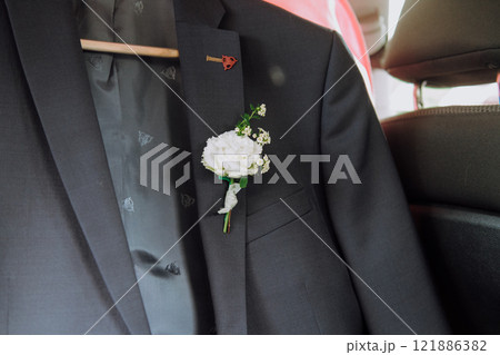 A welldressed man wearing a suit has a colorful flower tucked in his pocket A welldressed man wearing a suit has a colorful flower tucked in his pocket 121886382