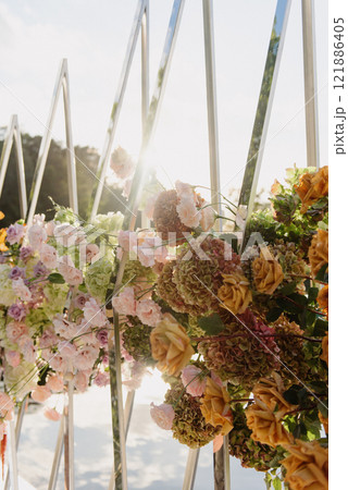 Flowers hanging from a fence with sunlight shining through Flowers hanging from a fence with sunlight shining through 121886405