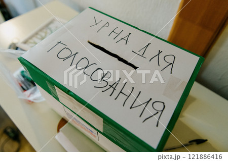 A green box that has Russian writing on it is placed on a table A green box that has Russian writing on it is placed on a table 121886416