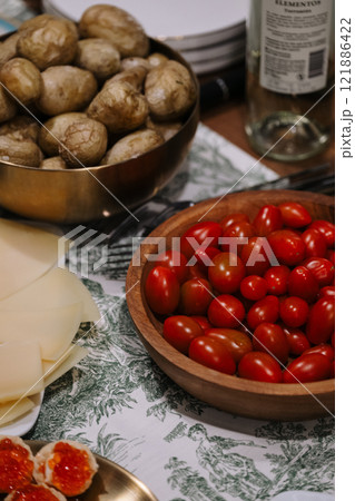 A table has one bowl of potatoes and another of tomatoes A table has one bowl of potatoes and another of tomatoes 121886422