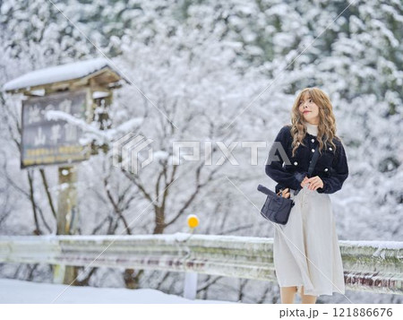 雪の中で散歩する女性 121886676