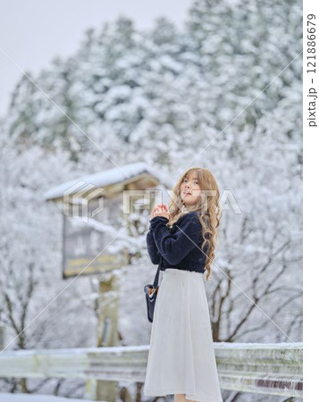 雪の中で散歩する女性 121886679