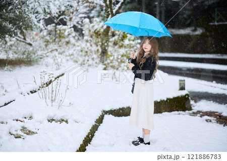 雪の中で散歩する女性 121886783